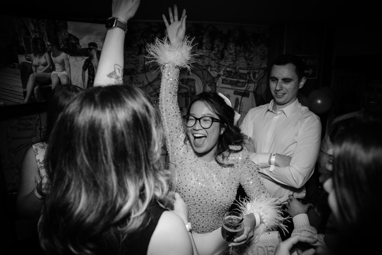 Candid party photography showing joyful dancing at Emily and James’s London engagement celebration.